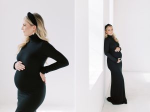 woman in black gown leans against white wall during studio maternity portraits