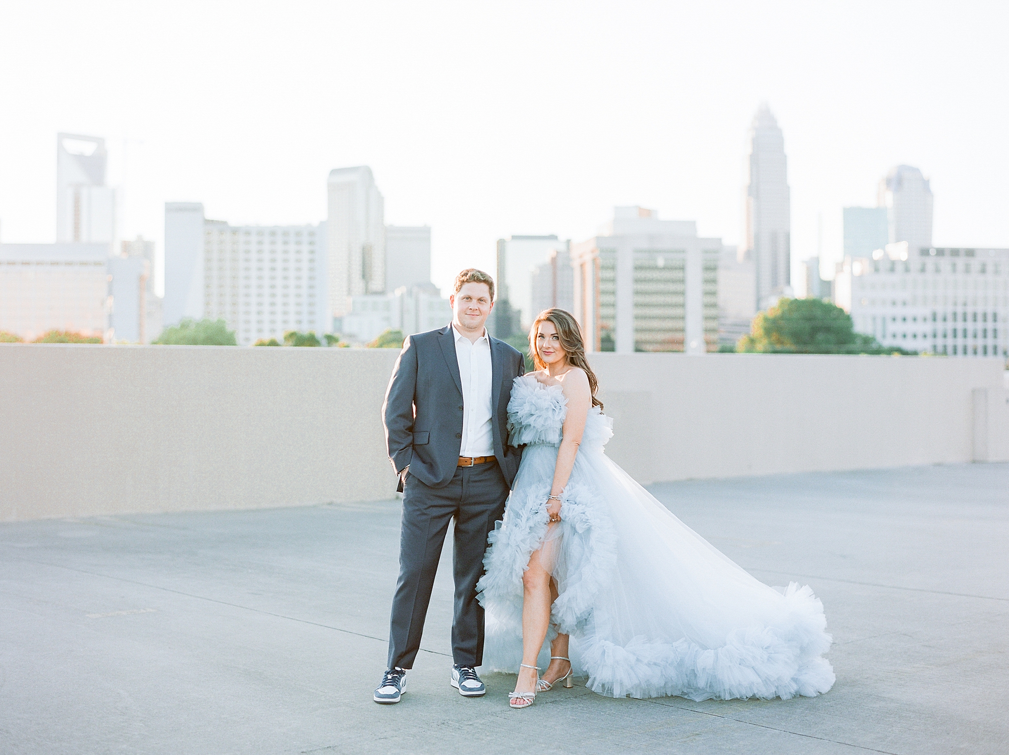 engaged couple stands on Charlotte rooftop during glam Charlotte engagement session