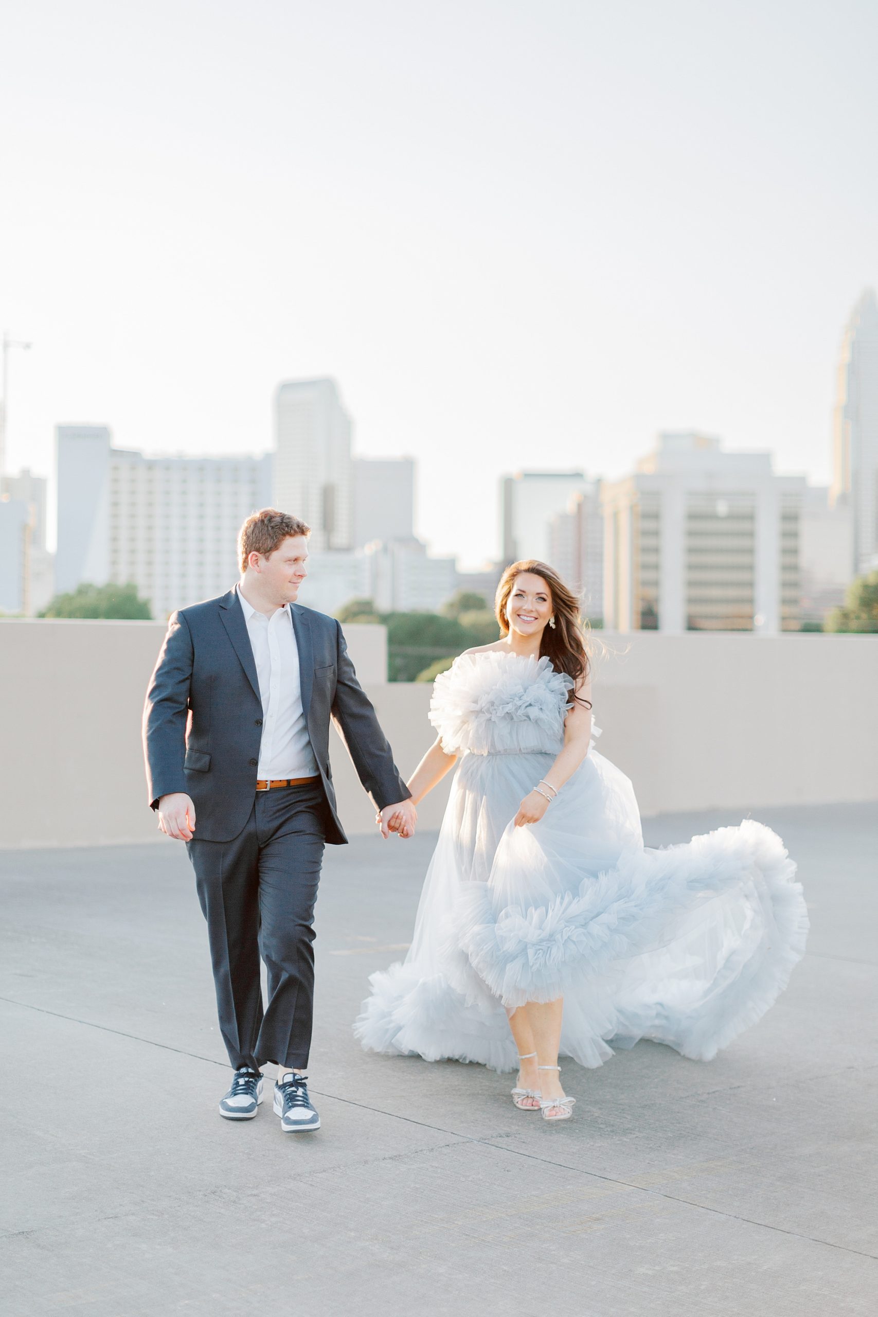 bride twirls skirt of dramatic blue dress during glam Charlotte engagement session