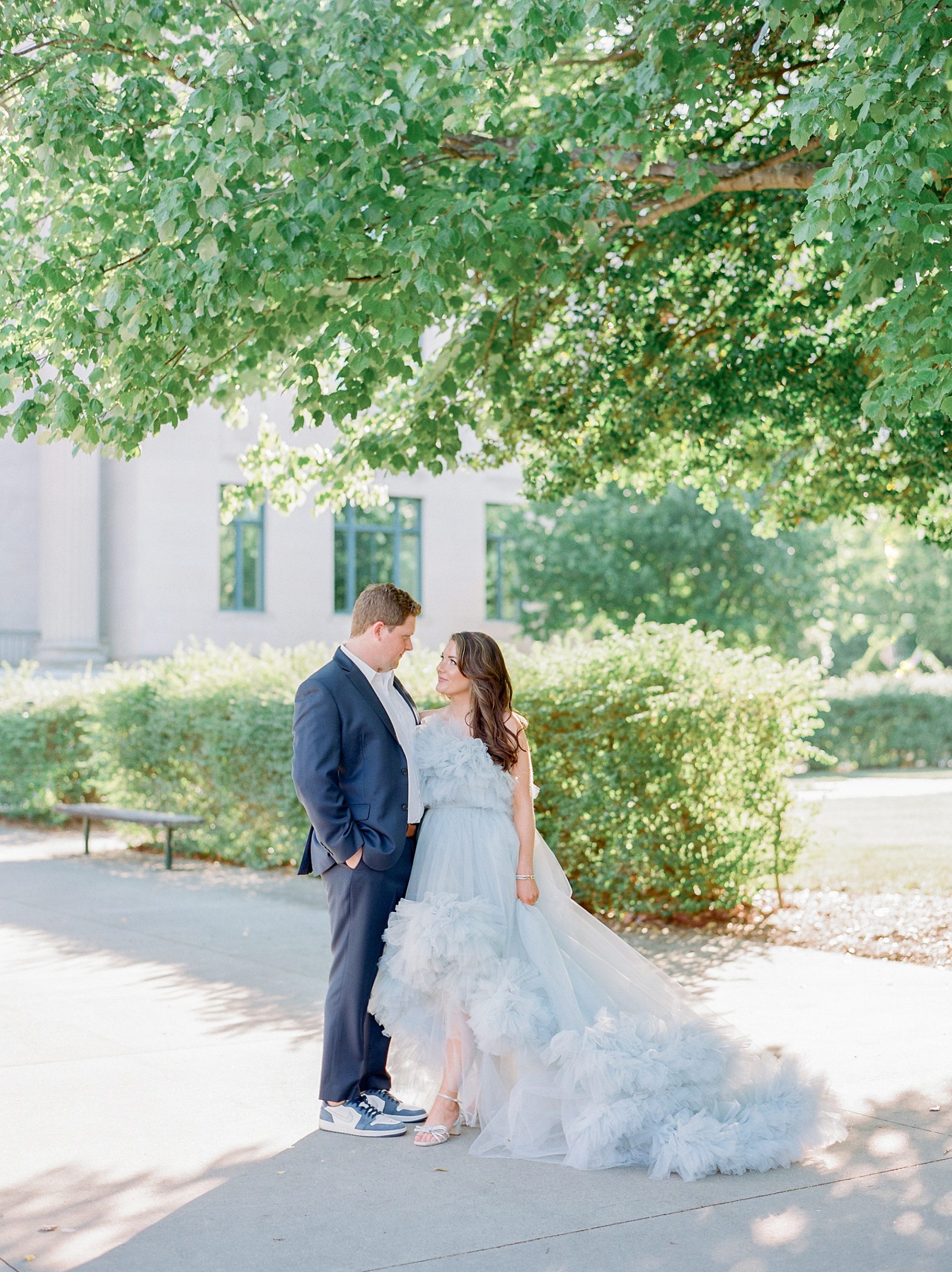 bride looks up at groom in blue gown during glam Charlotte engagement session