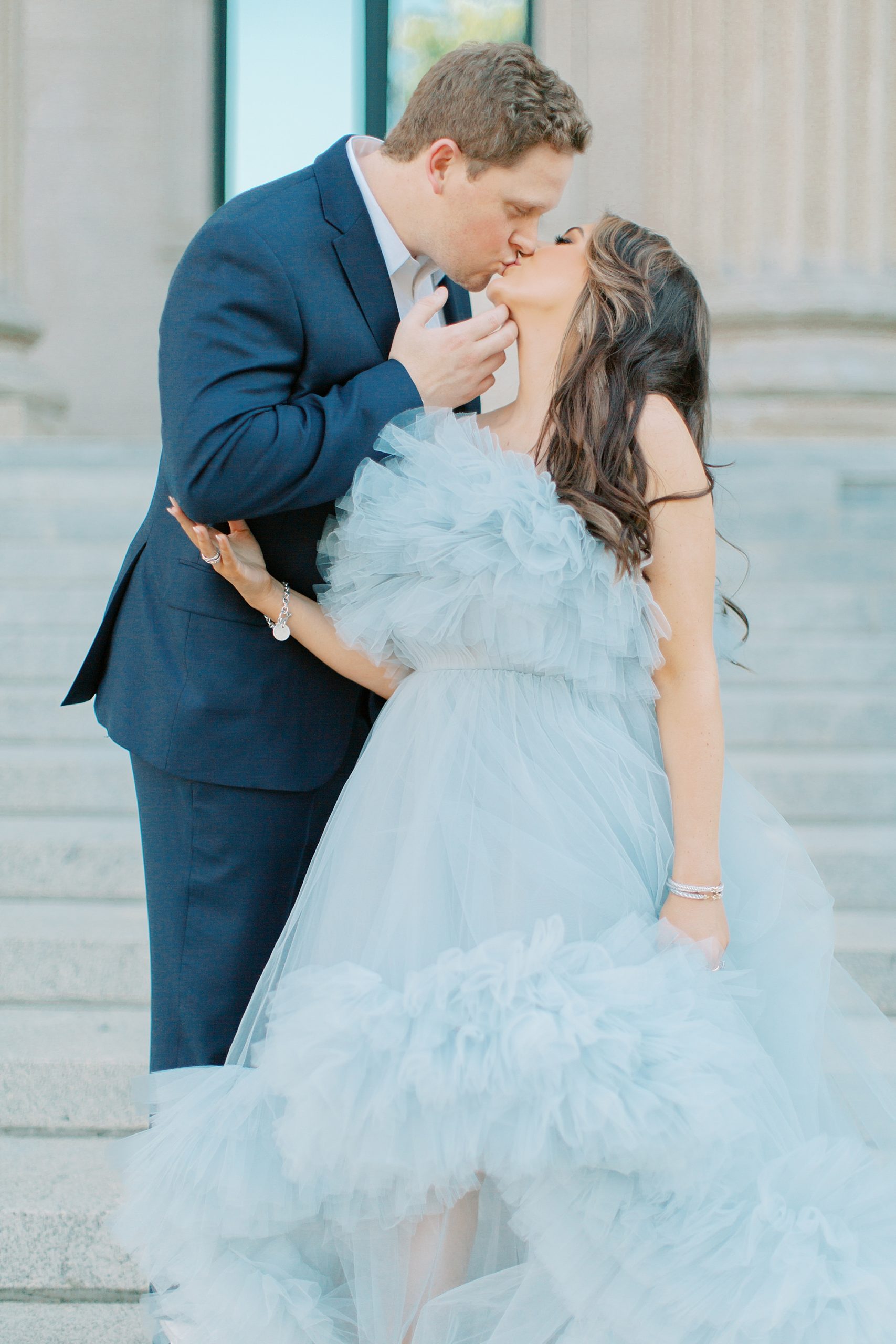 couple kisses on steps of courthouse during glam Charlotte engagement session