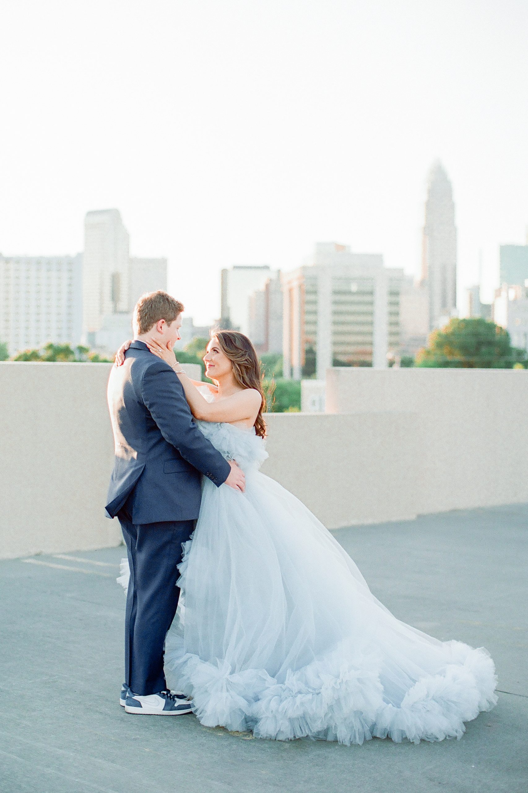 bride and groom hug on rooftop in Charlotte NC