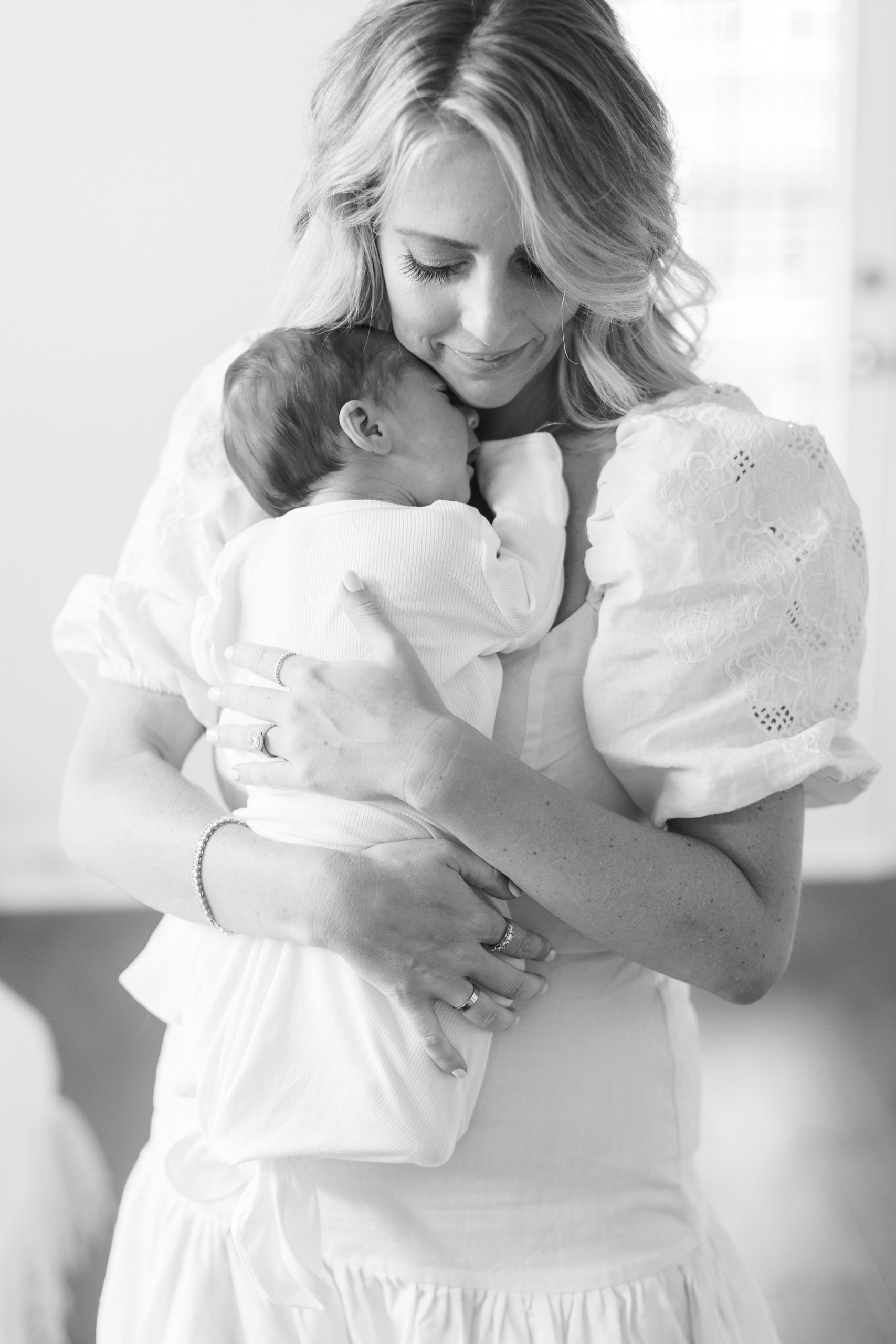 mom holds baby boy on chest during Charlotte lifestyle newborn session
