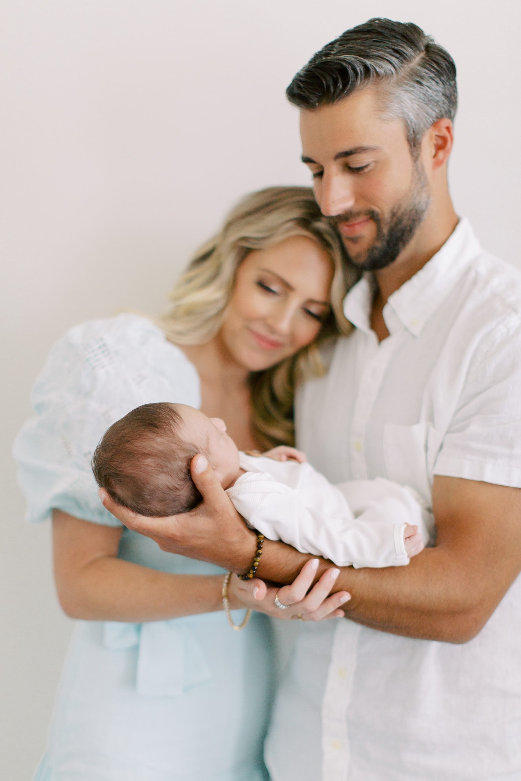 new parents of baby boy look at son during Charlotte lifestyle newborn session