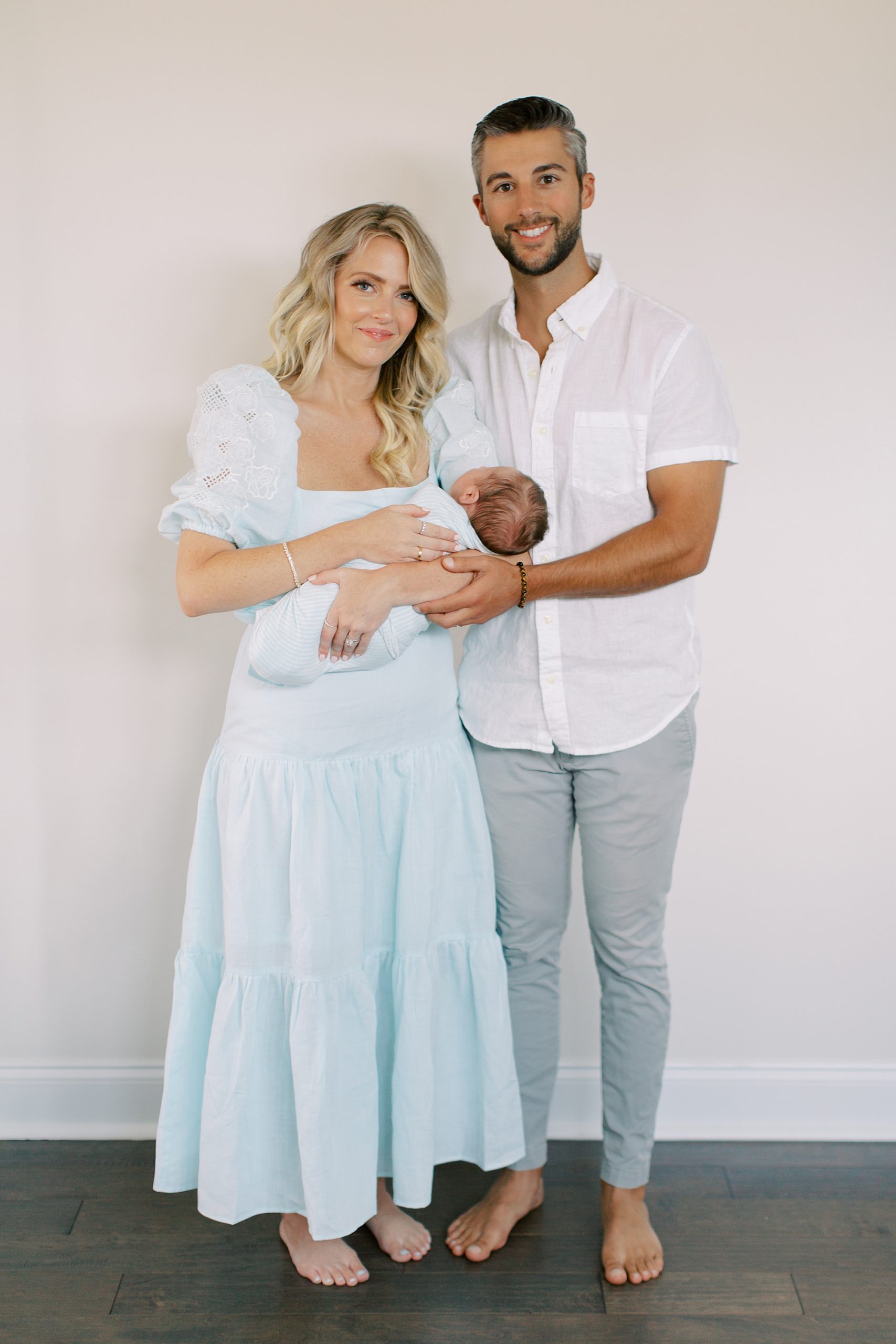 new parents stand in home during lifestyle newborn session