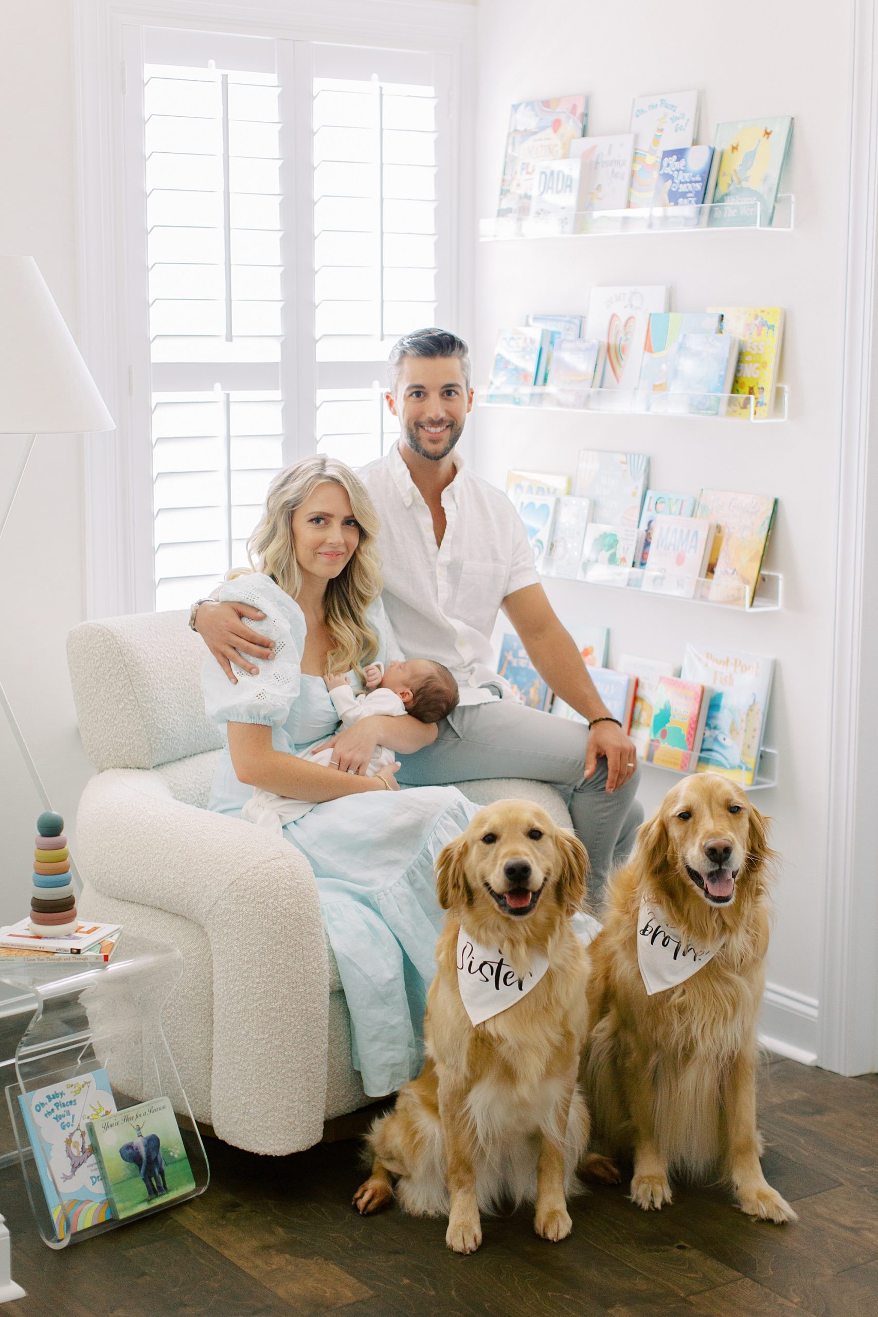 parents sit in nursery with new son and two dogs