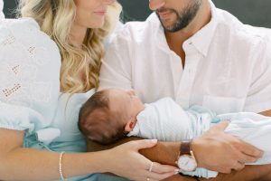 new parents snuggle with son during lifestyle newborn photos