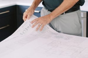 man lays out blueprints during Charlotte branding portraits for construction company