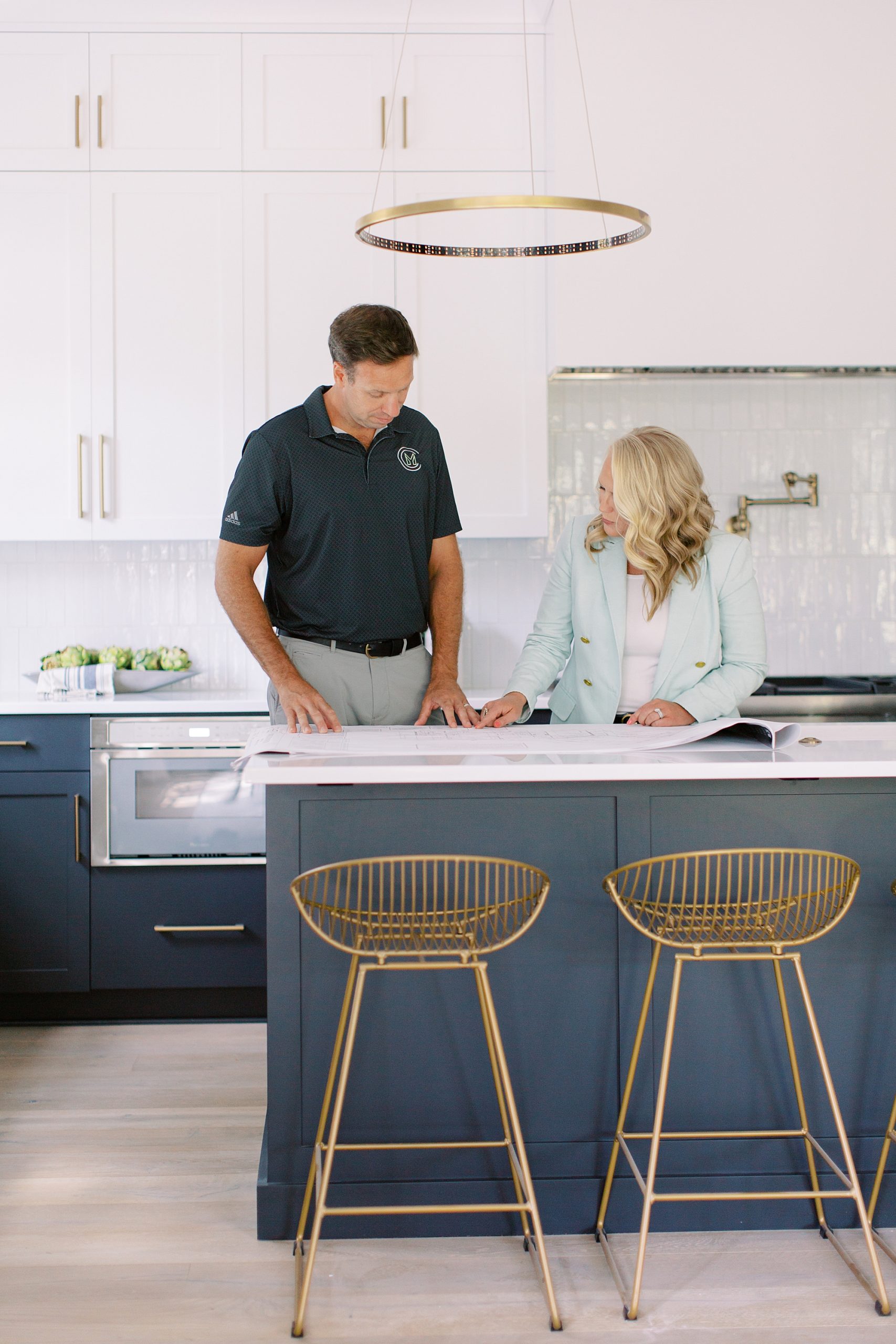 husband and wife work at kitchen island during Charlotte branding portraits for construction company
