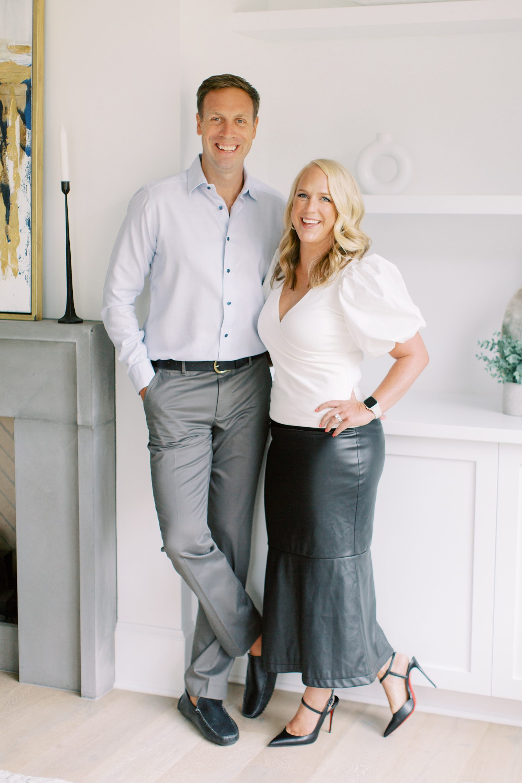 husband and wife pose together in kitchen during Charlotte branding portraits for construction company