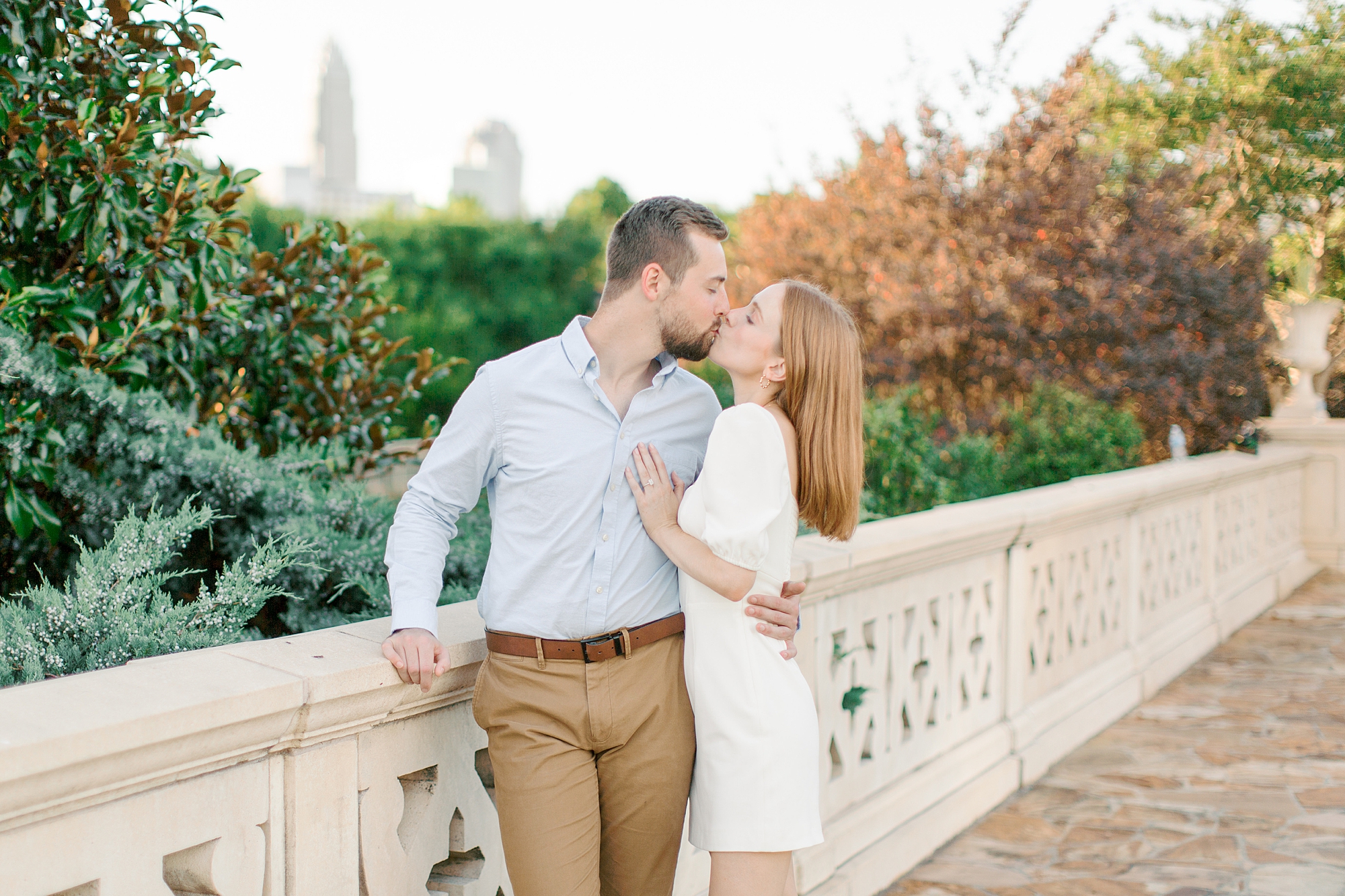 bride and groom kiss on bridge in Charlotte park