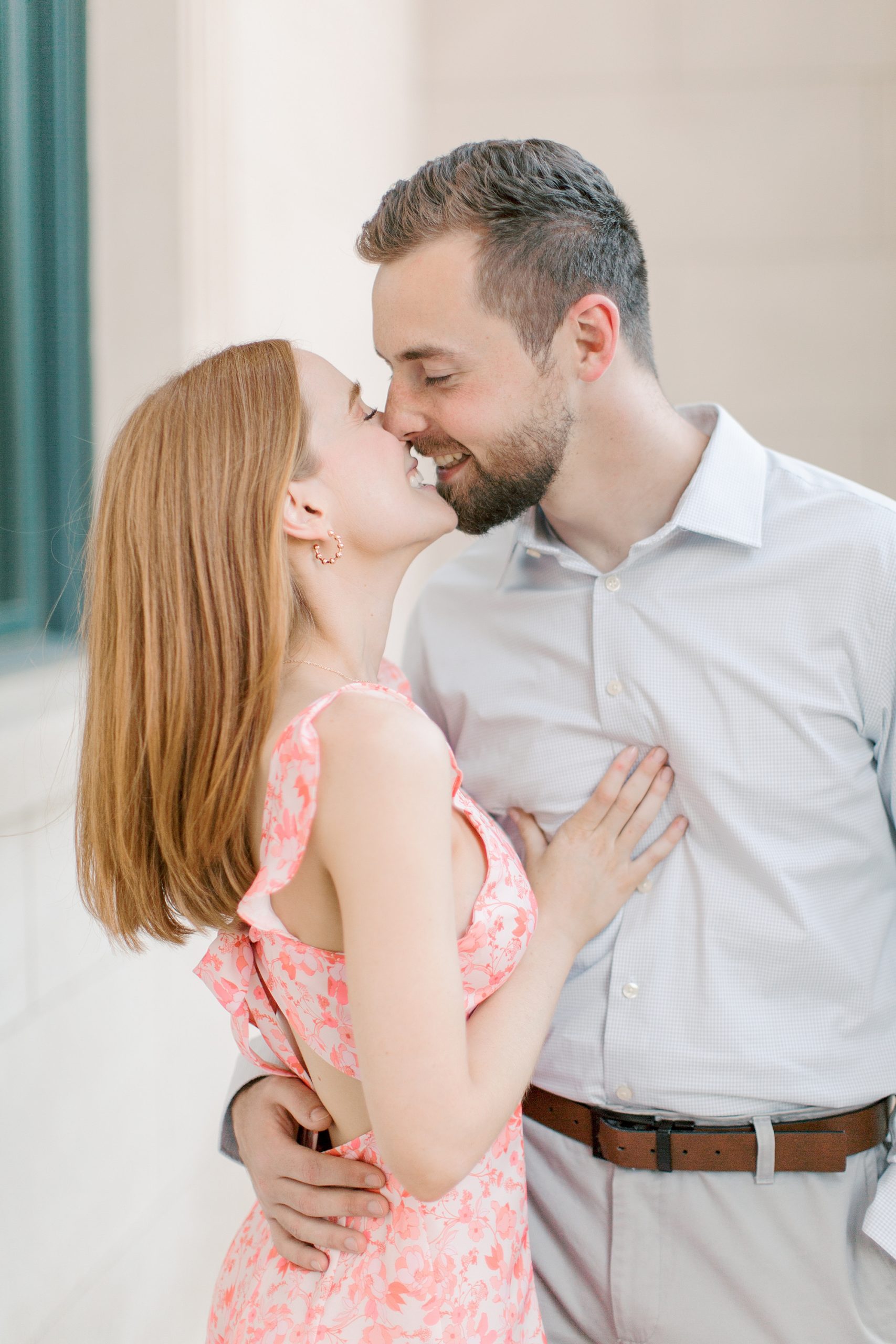 engaged couple leans in for kiss during portraits in Uptown Charlotte