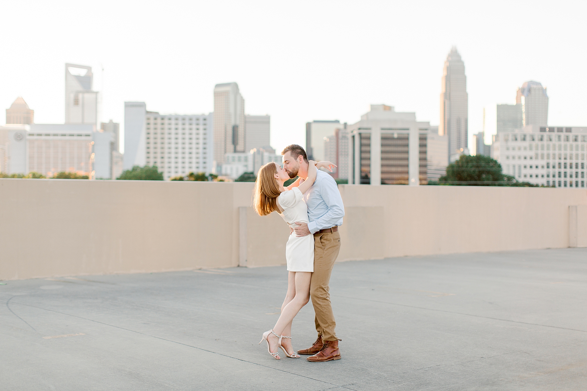 engaged couple hugs together on parking deck in Uptown Charlotte