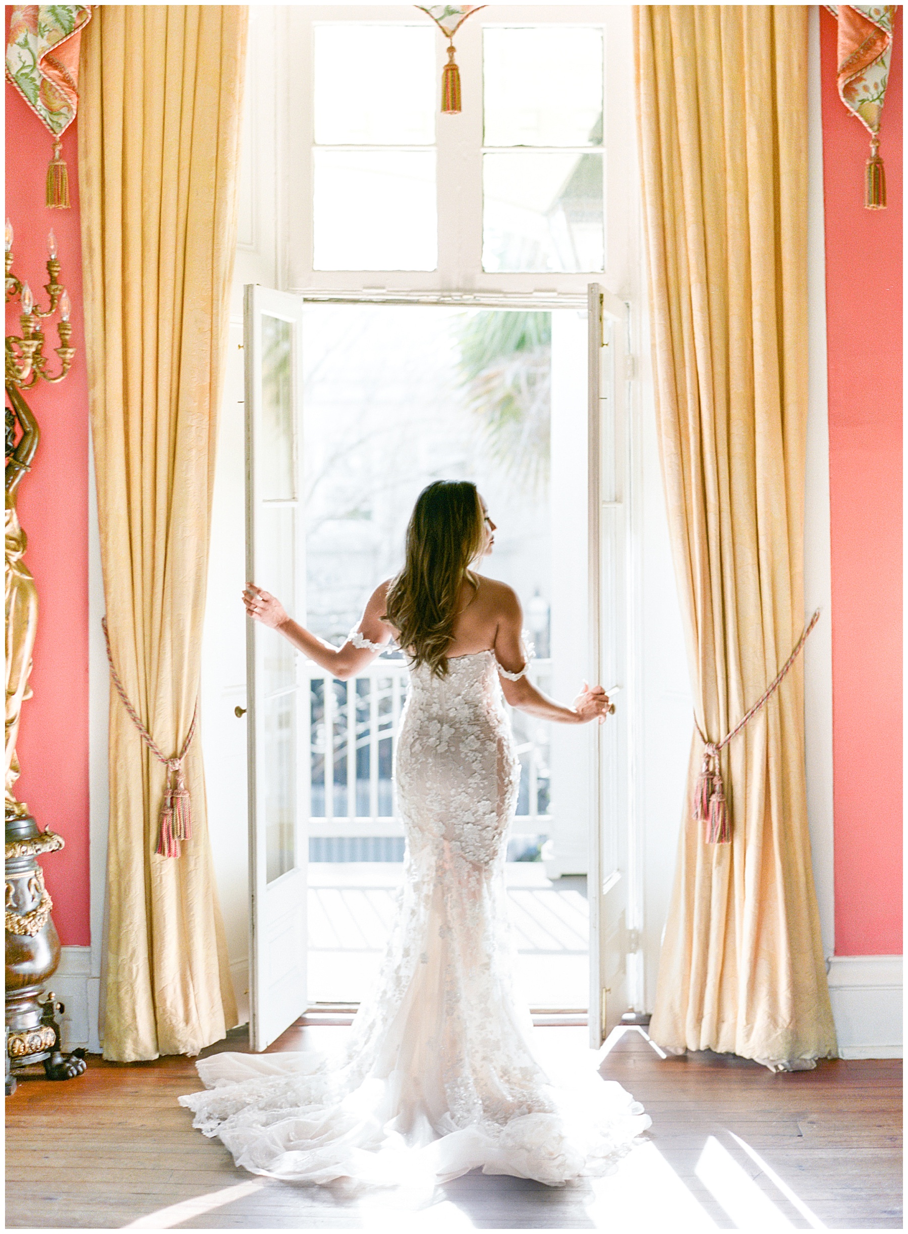 bride opens door inside pink room of the William Aiken House
