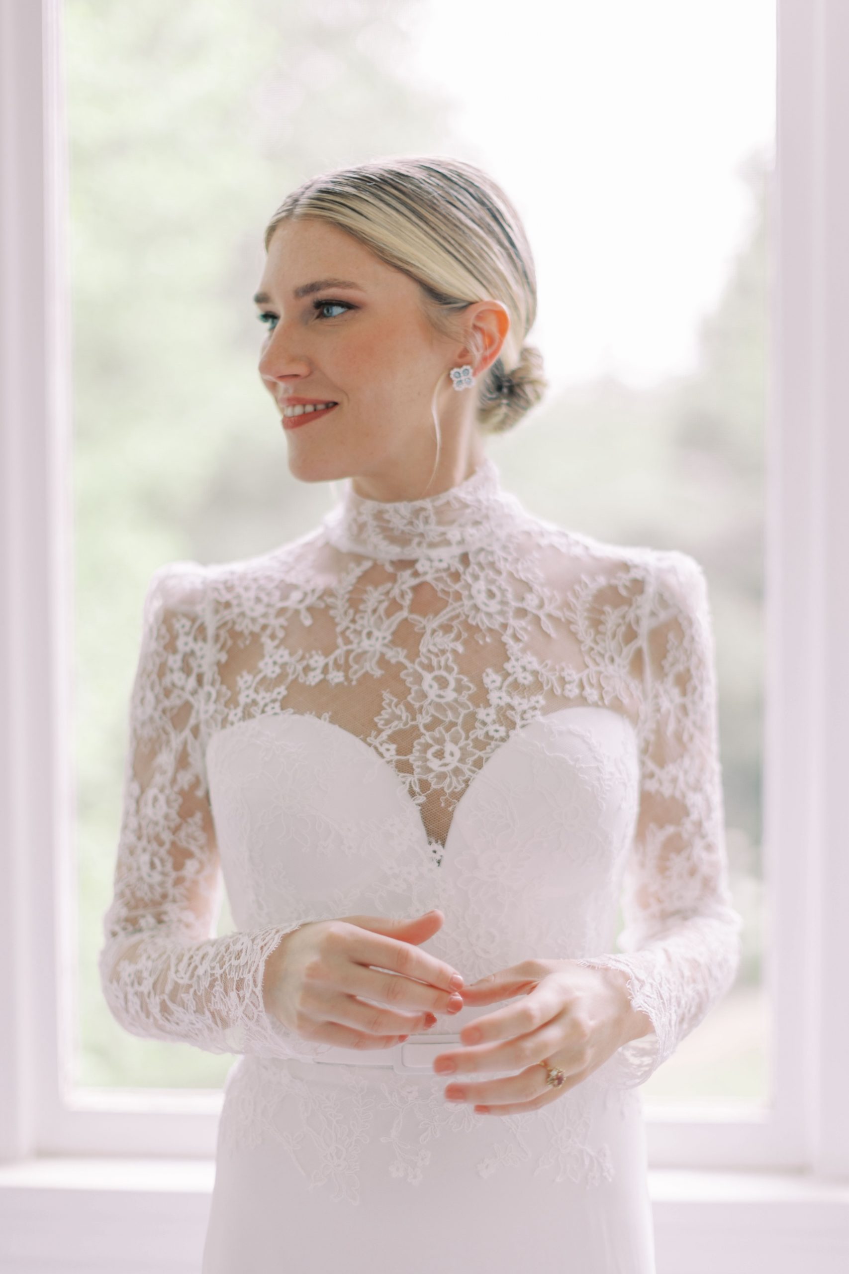 groom stands in wedding gown with lace top for bridal look inspired by Grace Kelly
