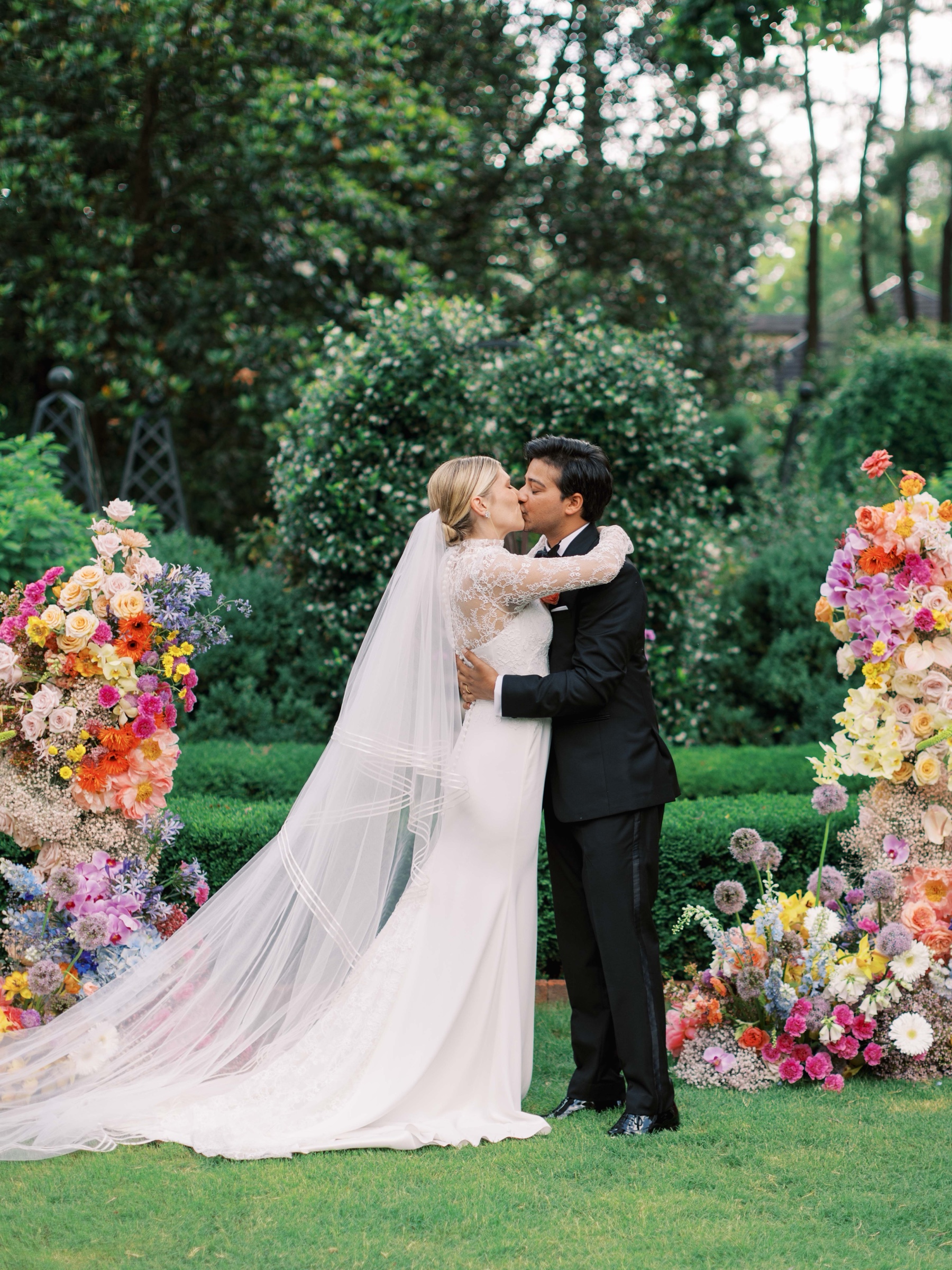bride and groom kiss in gardens during wedding ceremony at Duke Mansion 