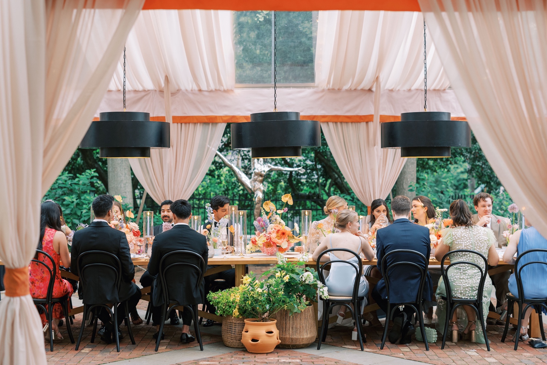 wedding guests sit at long family style seating tables for Duke Mansion wedding reception 